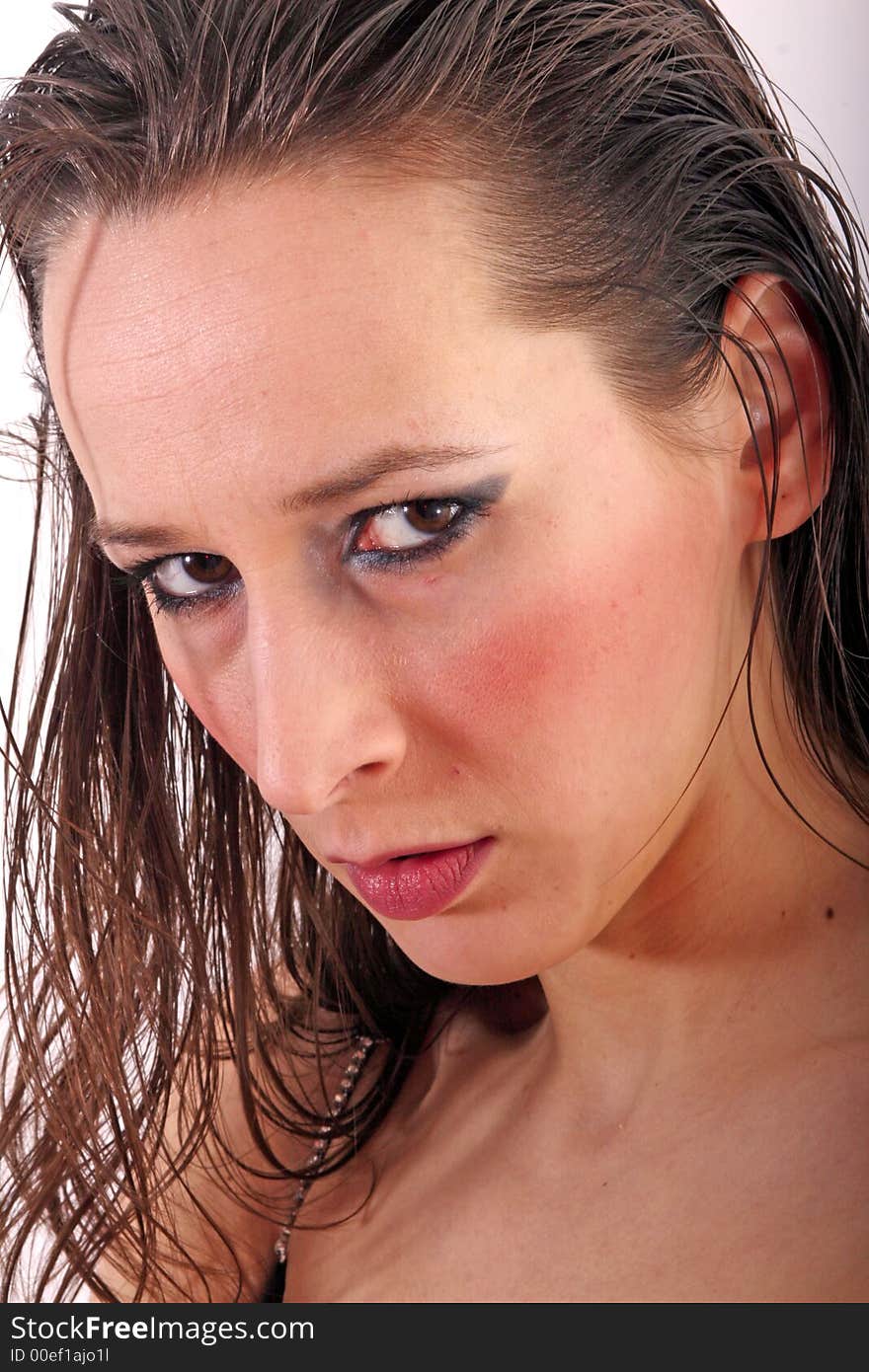 Close-up shot of a young woman with wet look hair looking angry. Close-up shot of a young woman with wet look hair looking angry