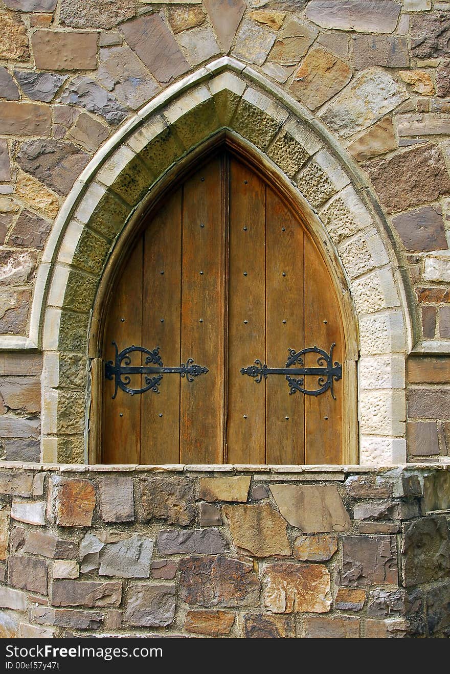 Medieval architecture with an old wooden arched doorway. Medieval architecture with an old wooden arched doorway