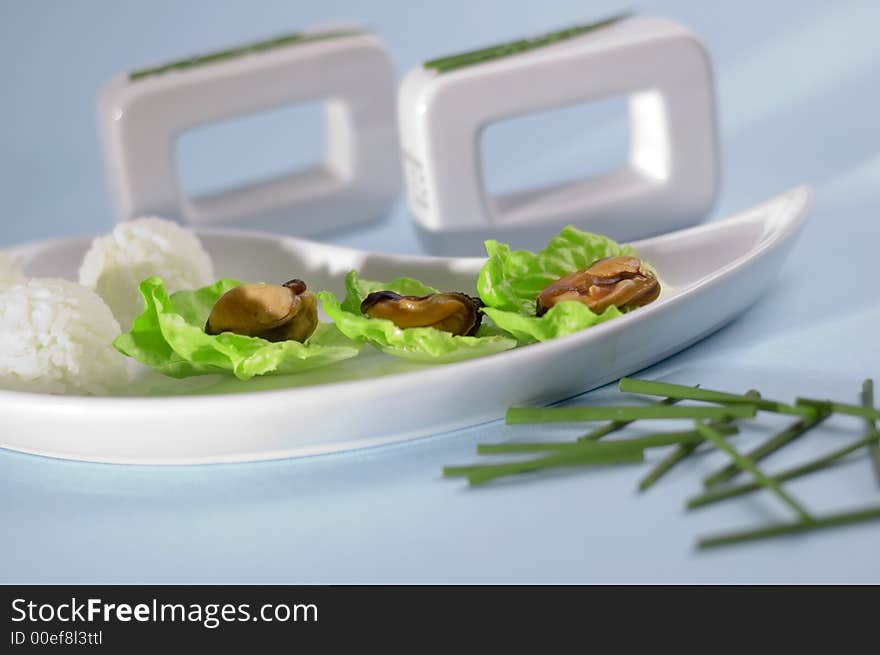 Shells with salad and rice on the blue background