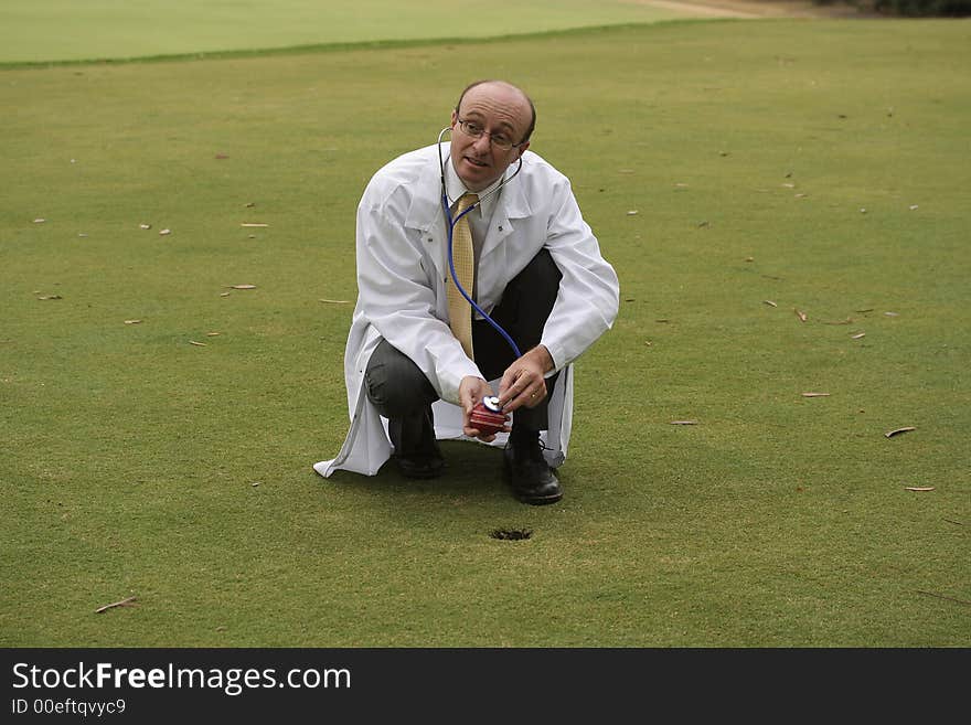 Medical doctor on the golf course checking a red cricket ball with his stethoscope, in the hope of helping you improve your game. Medical doctor on the golf course checking a red cricket ball with his stethoscope, in the hope of helping you improve your game