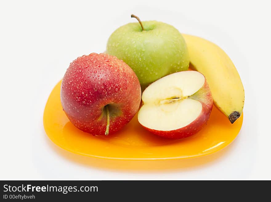 Red both green apples and banana on a yellow plate