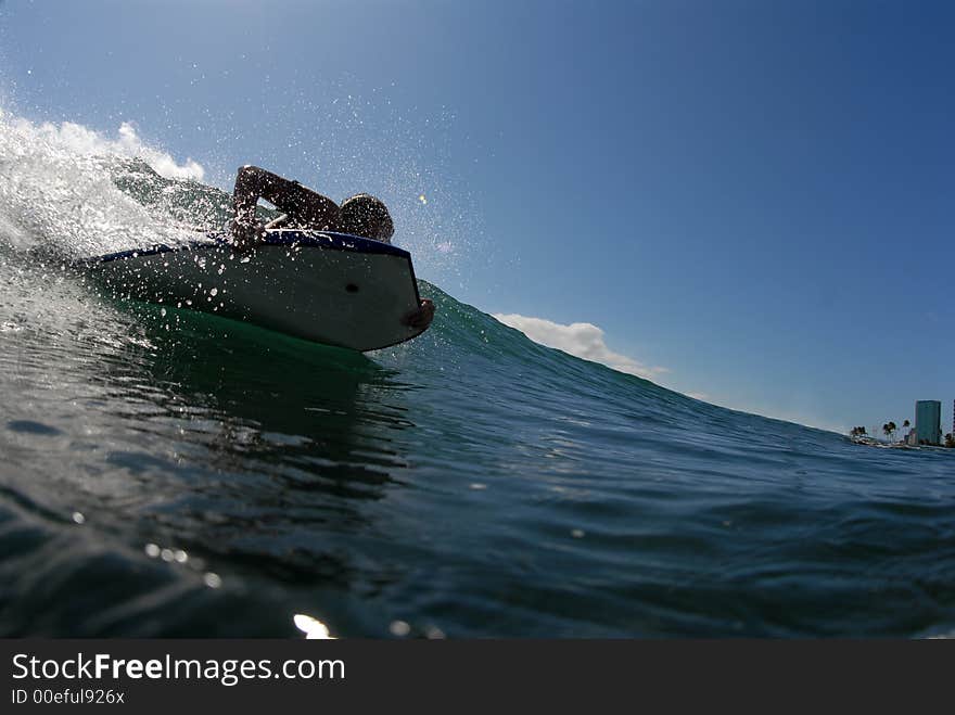 A boardyboarder surfing down a wave. A boardyboarder surfing down a wave.