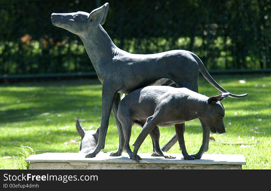 Statue of a typical mexican dog and the real dog under. Statue of a typical mexican dog and the real dog under