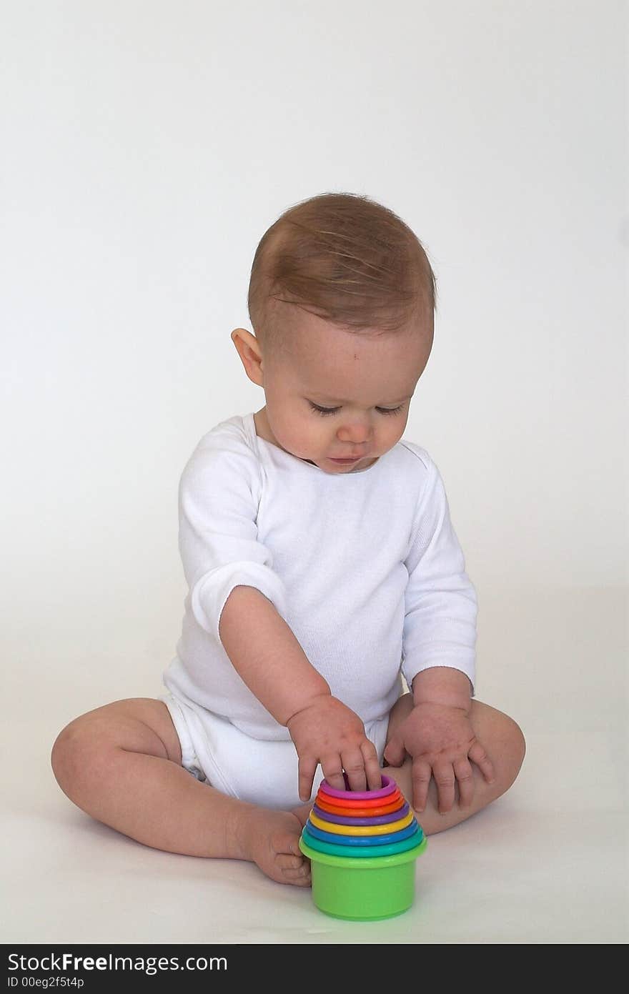 Image of adorable baby playing with stacking cups. Image of adorable baby playing with stacking cups