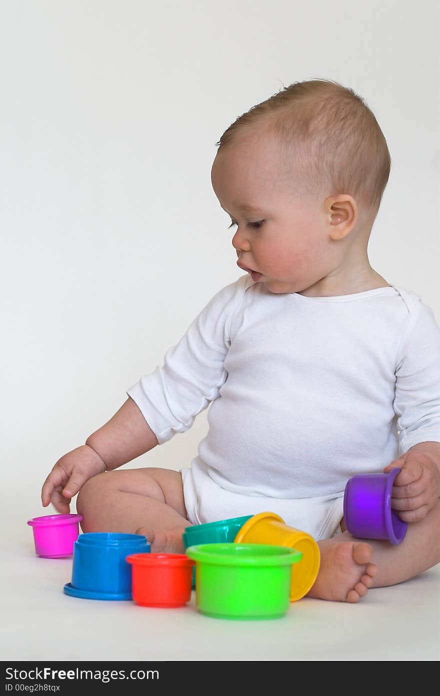 Image of adorable baby playing with stacking cups. Image of adorable baby playing with stacking cups