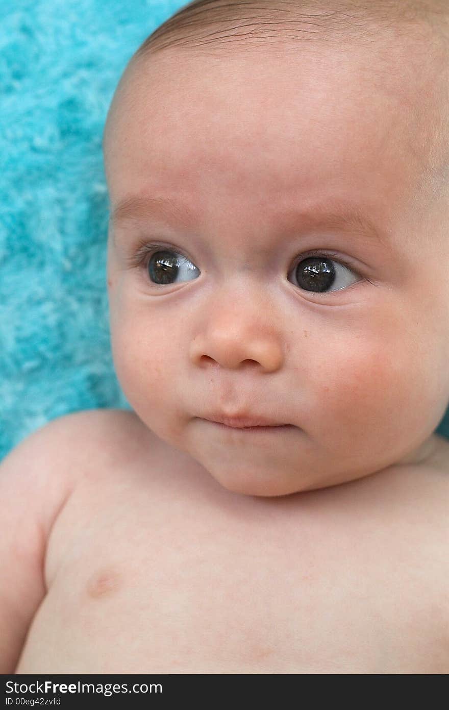 Image of beautiful 6 month old baby boy lying on a fuzzy turquoise blanket. Image of beautiful 6 month old baby boy lying on a fuzzy turquoise blanket