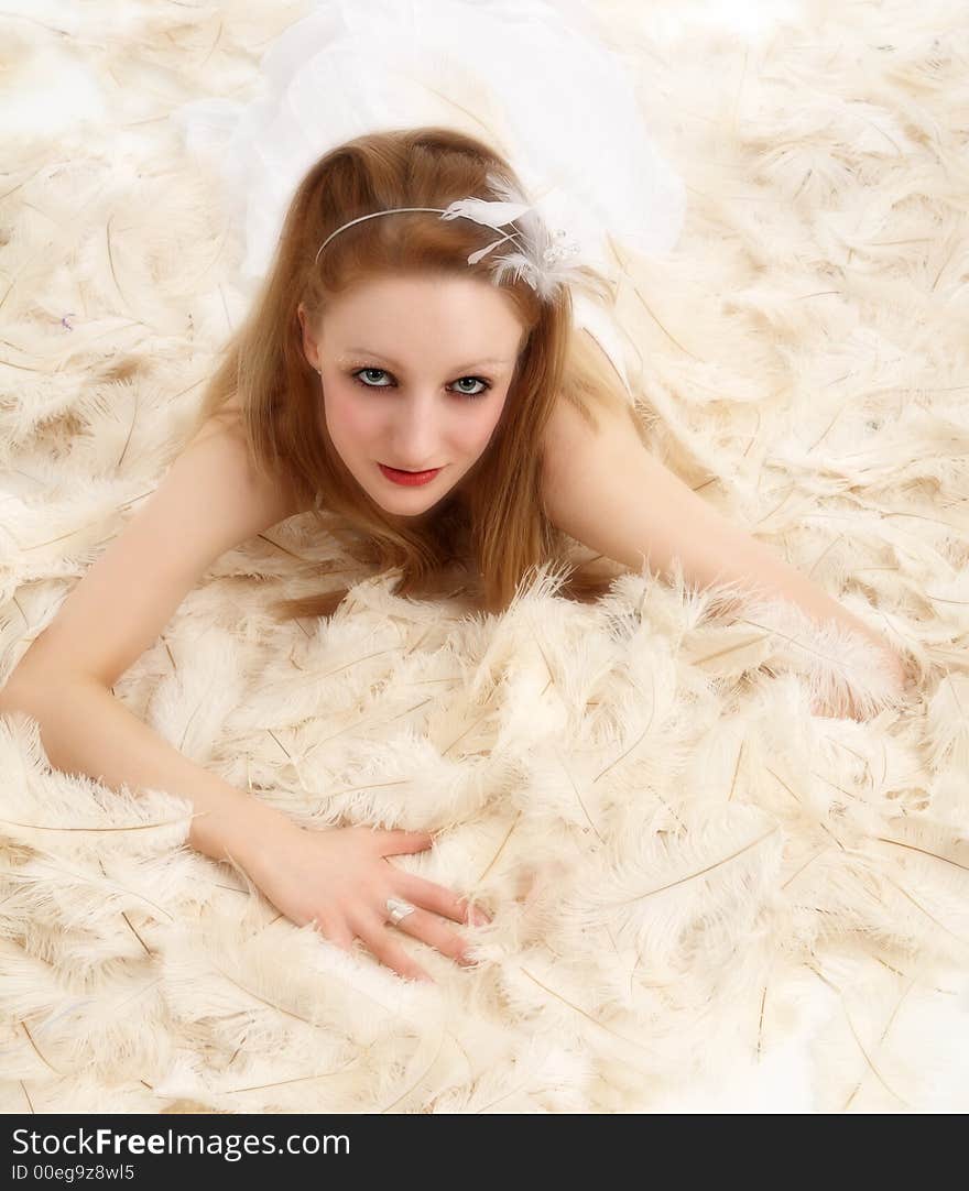 Young woman lying on hundreds of ostrich feathers. Young woman lying on hundreds of ostrich feathers