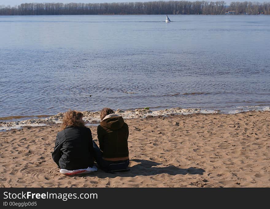 Two girls sitting on the beach