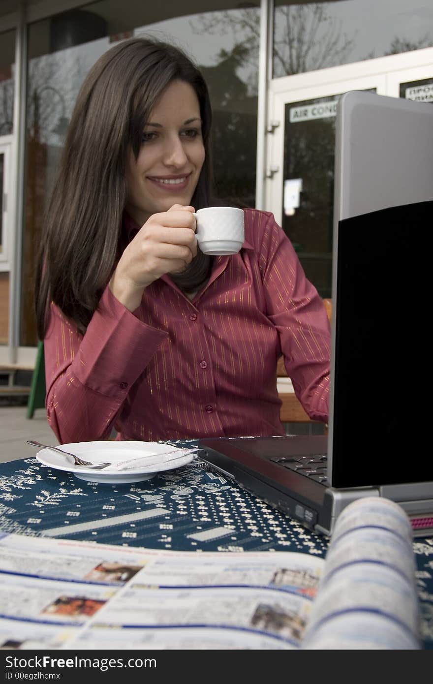 Businesswoman sitting in cafe and working on laptop