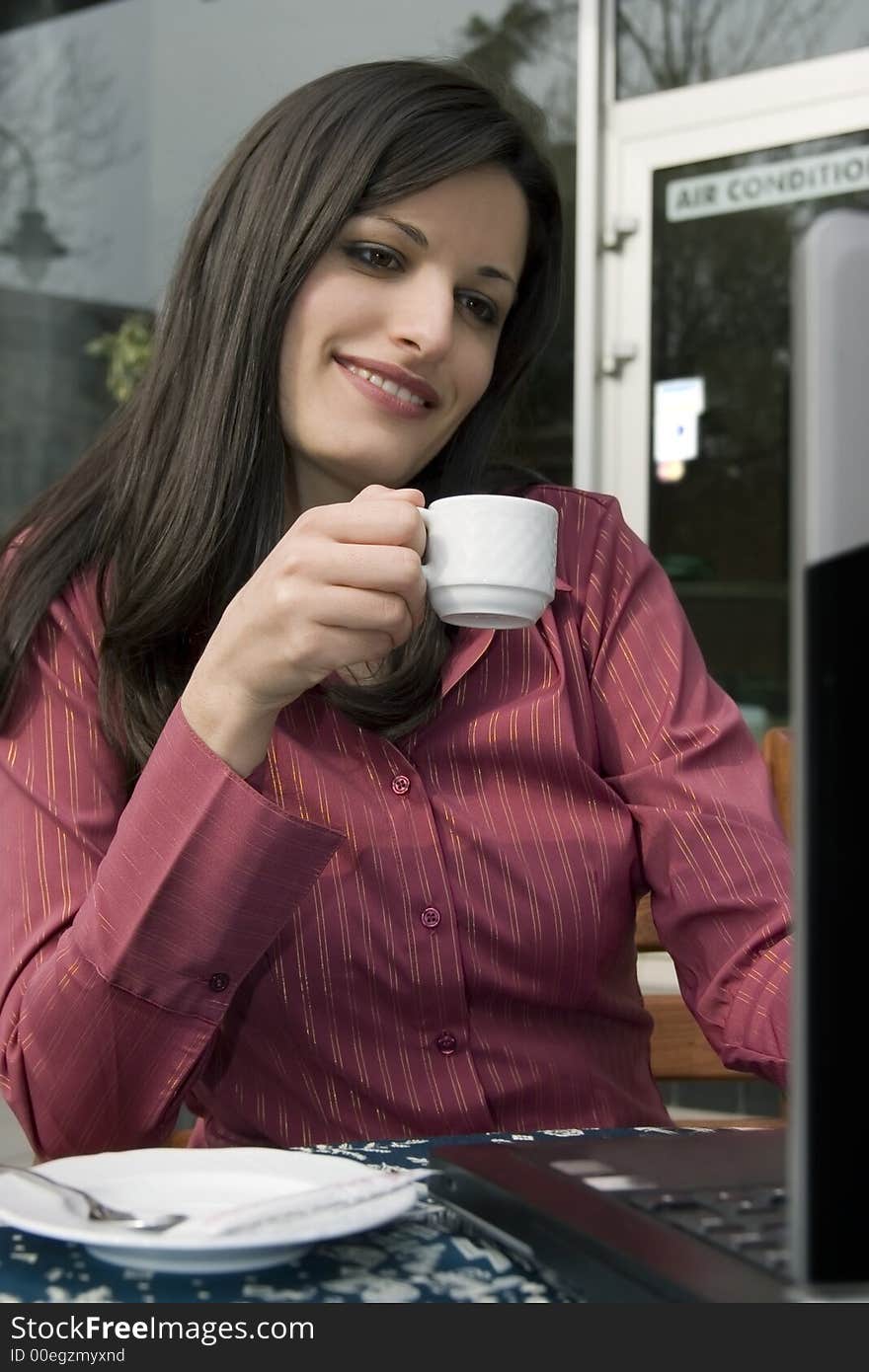 Businesswoman sitting in cafe and working on laptop