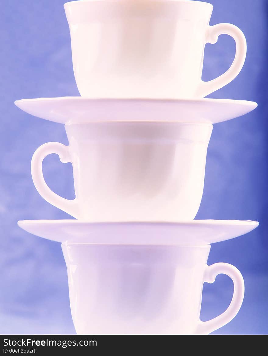 Pure white cups on  blue background, close up