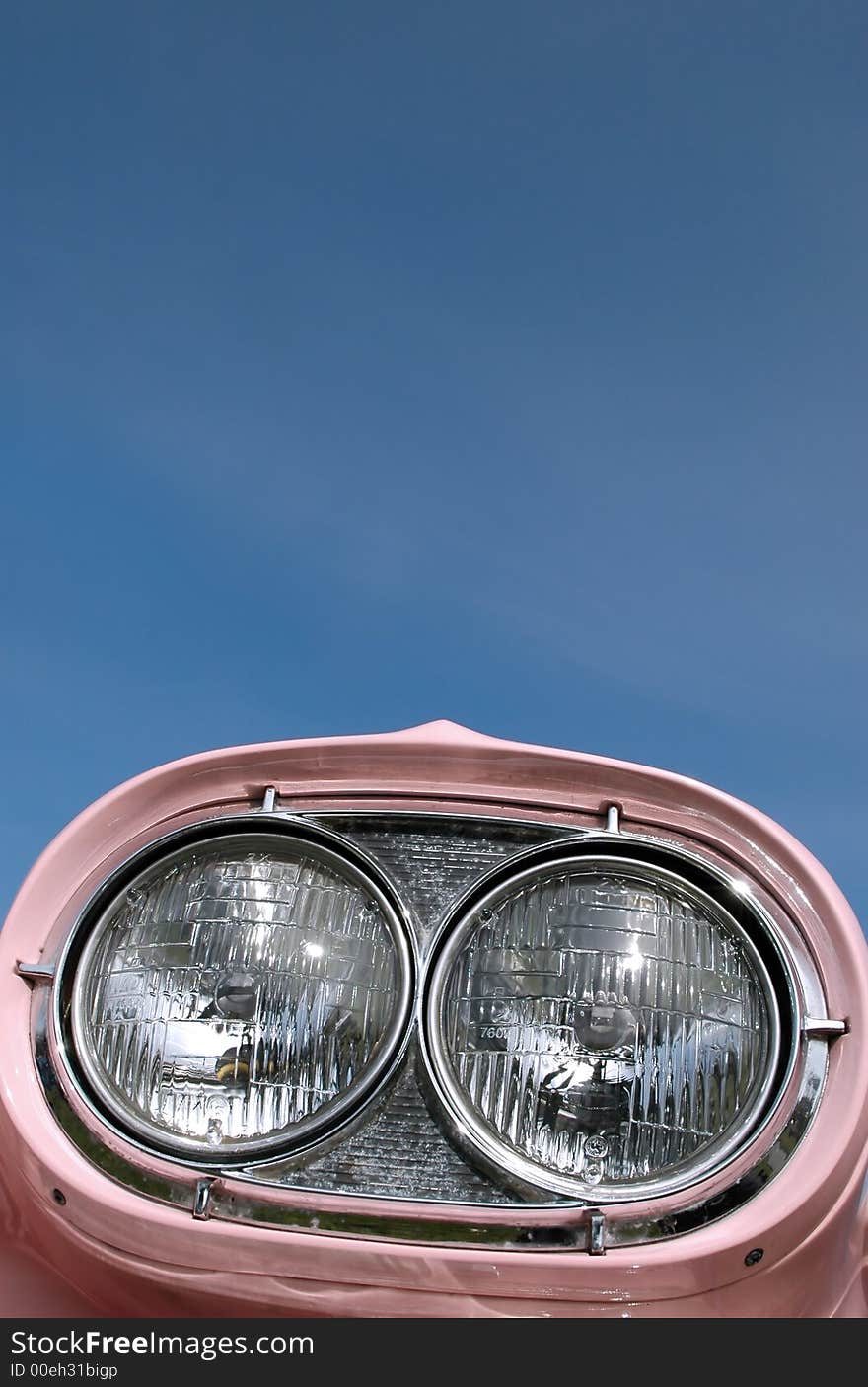 Pink classic car headlamps against blue sky. Pink classic car headlamps against blue sky