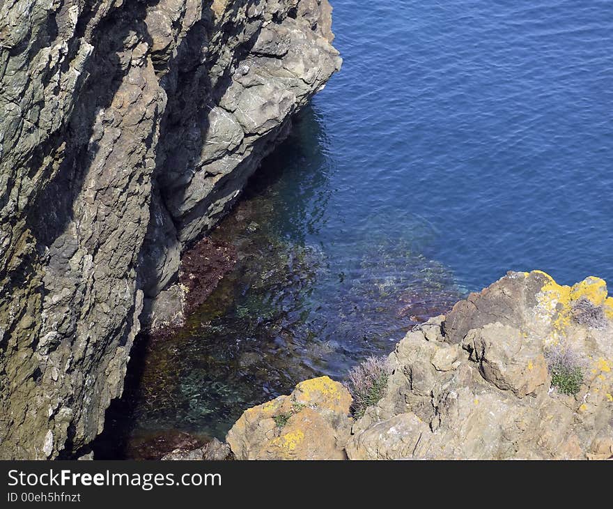 A blue and transparent sea between the rocks on the coast