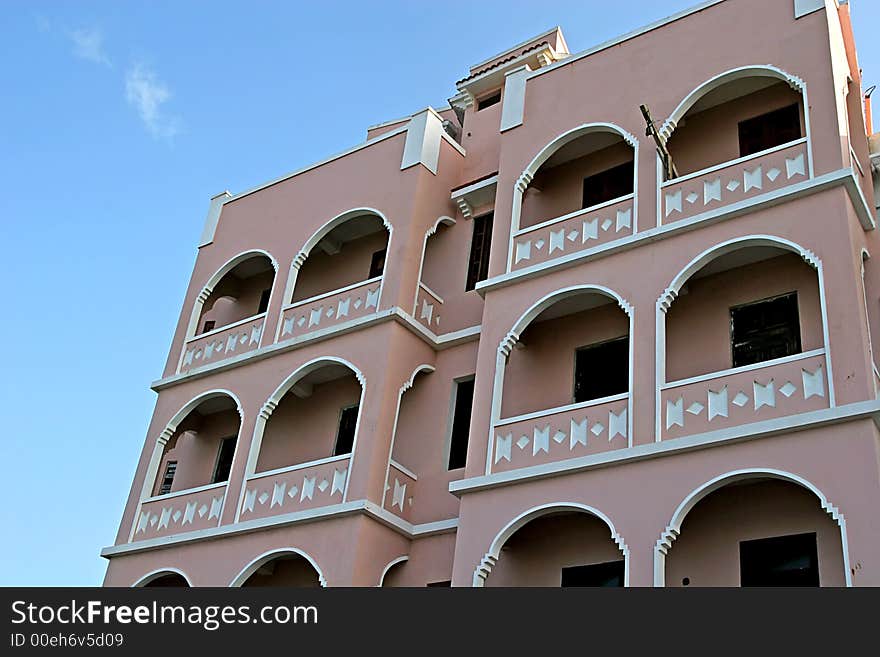 Pink stucco apartment building in tropical area. Pink stucco apartment building in tropical area