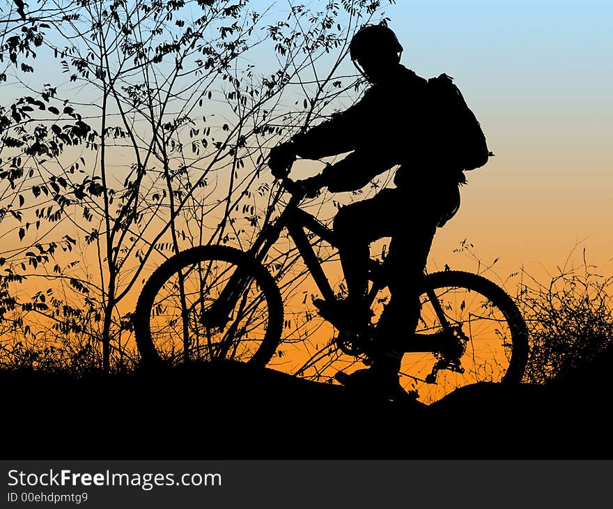 Mountain biker silhouette with orange sunrise