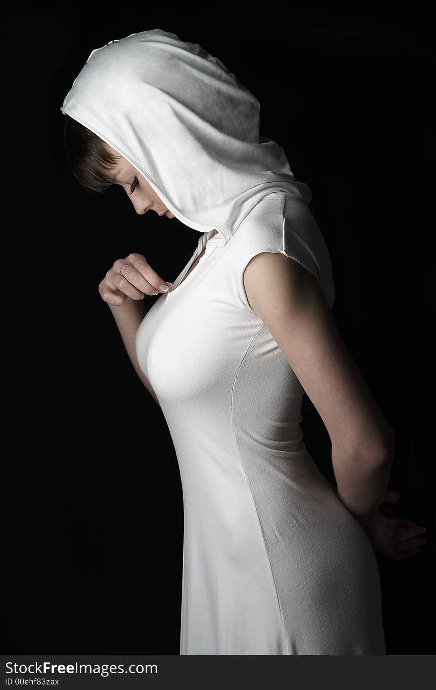 Young charming girl in white dress with hook on black background