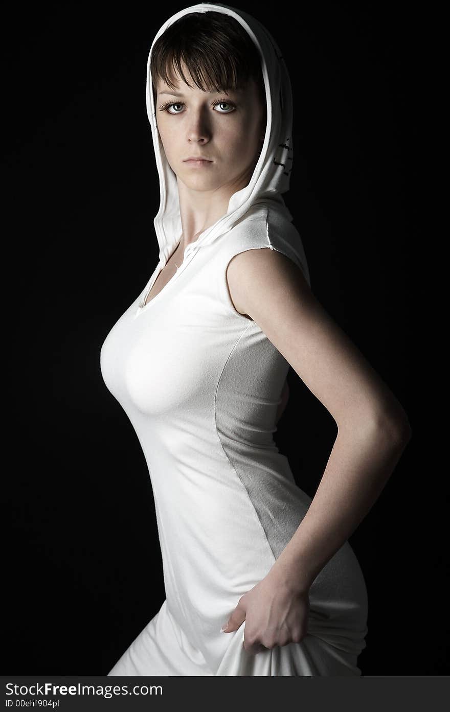 Young charming girl in white dress with hook on black background