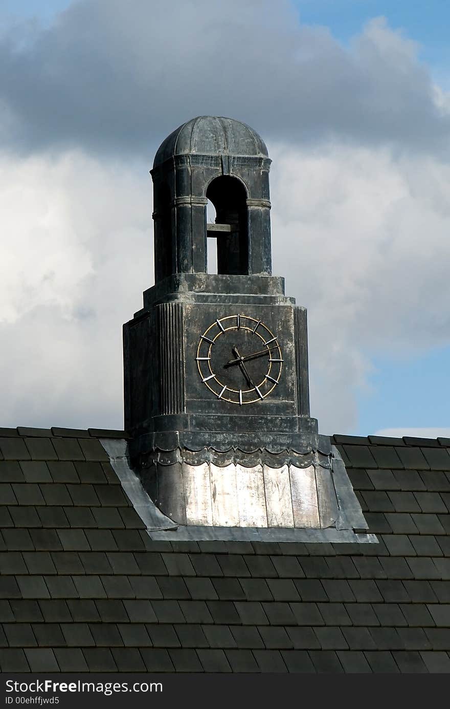 An old clock tower on the top of a roof.