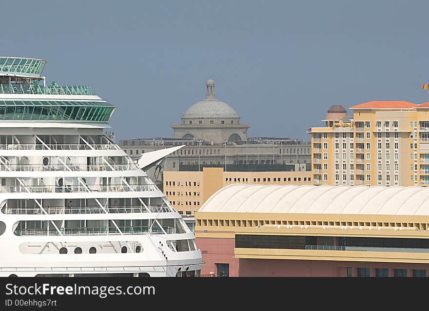 A cruise ship docked in a busy port city. A cruise ship docked in a busy port city