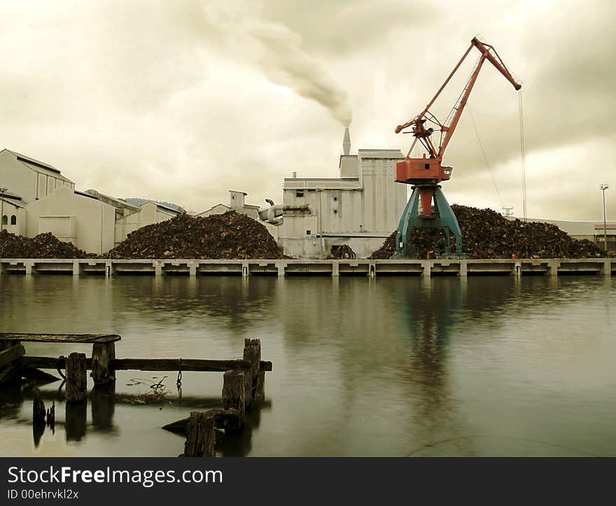 Industrial smoking chimney and crane by the river in Bilbao