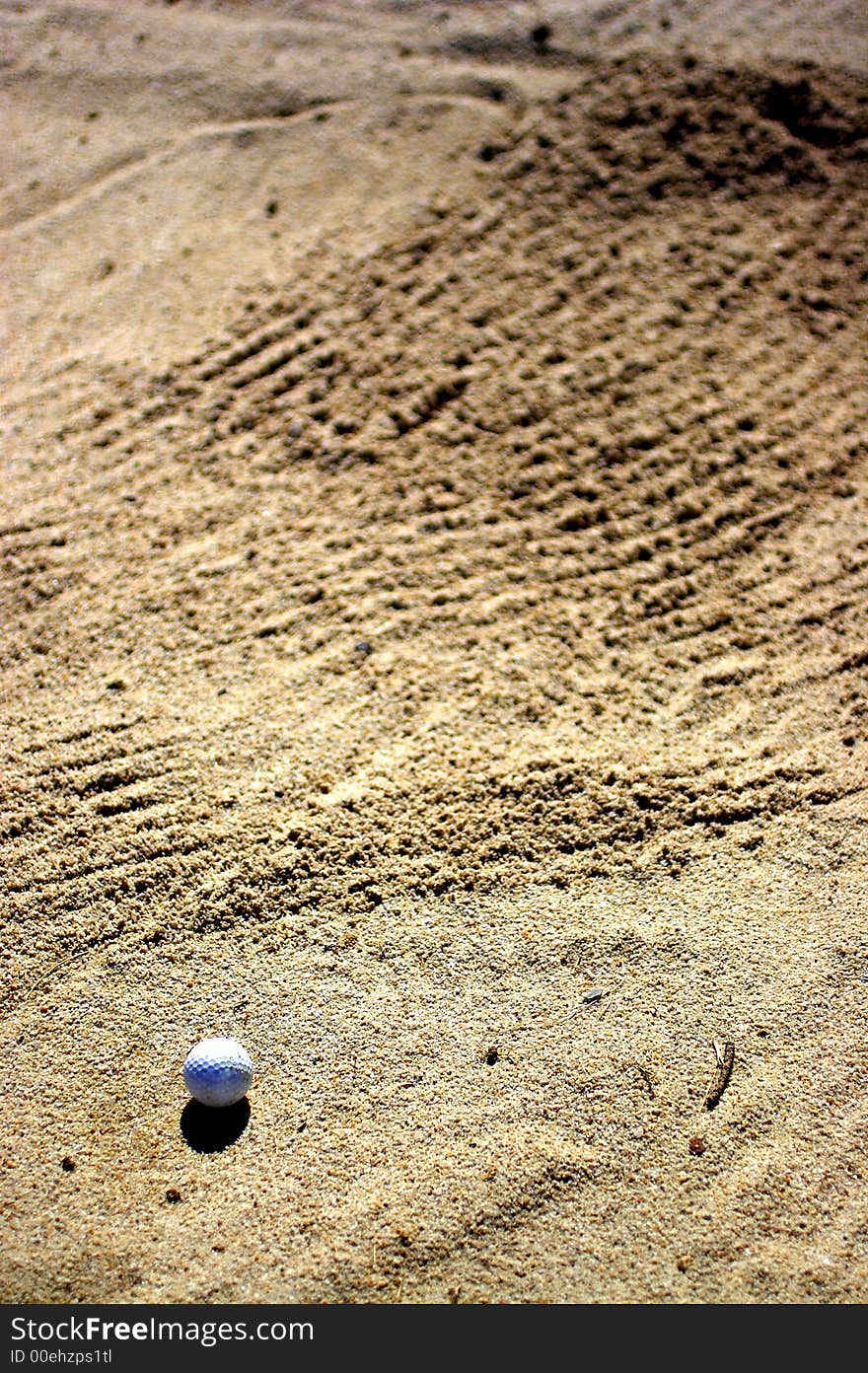 Ball of golf in bunker