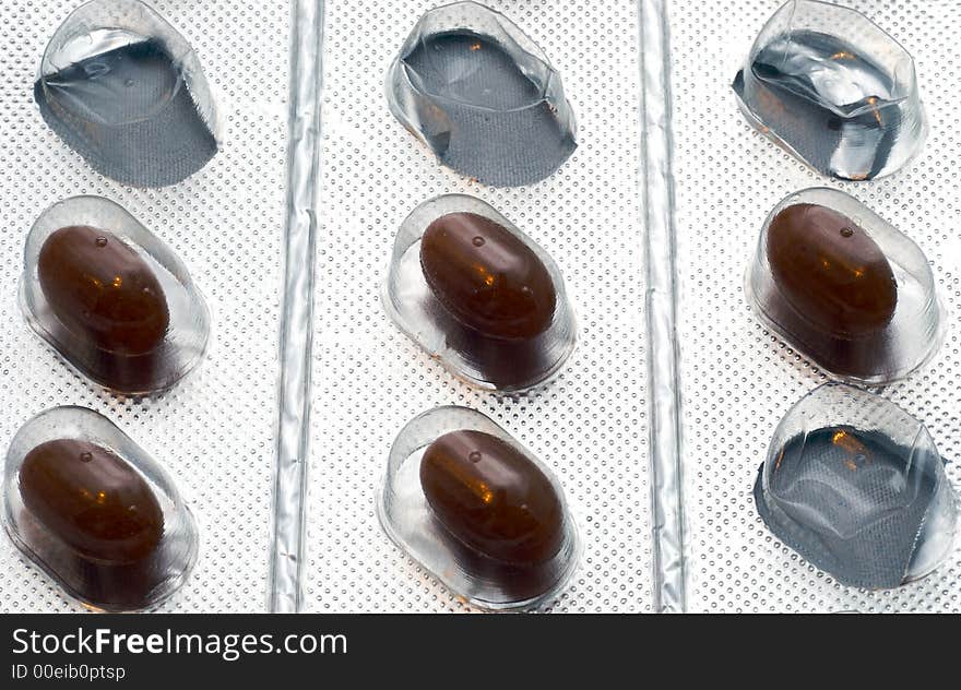 Four pills on a silver package  with three empty one