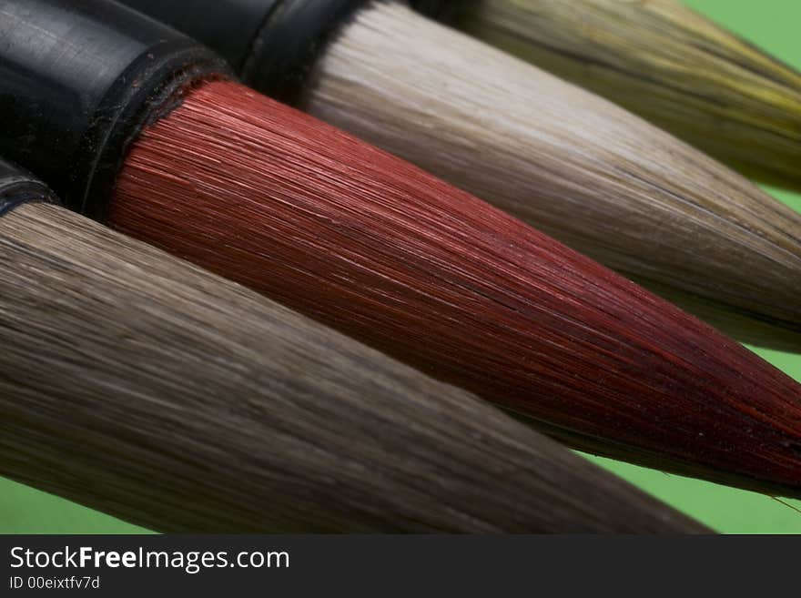 Macro Chinese art brush against a green background. Macro Chinese art brush against a green background