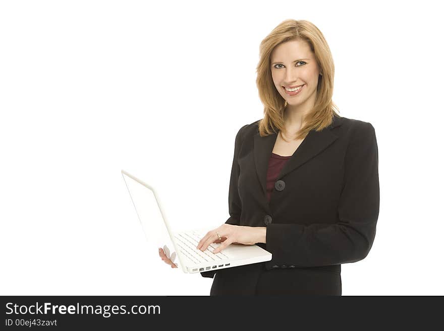 A businesswoman in a suit holds up a laptop. A businesswoman in a suit holds up a laptop