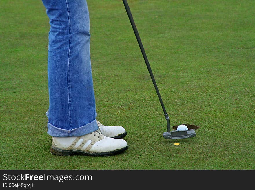 Woman putting the ball into the hole. Woman putting the ball into the hole.