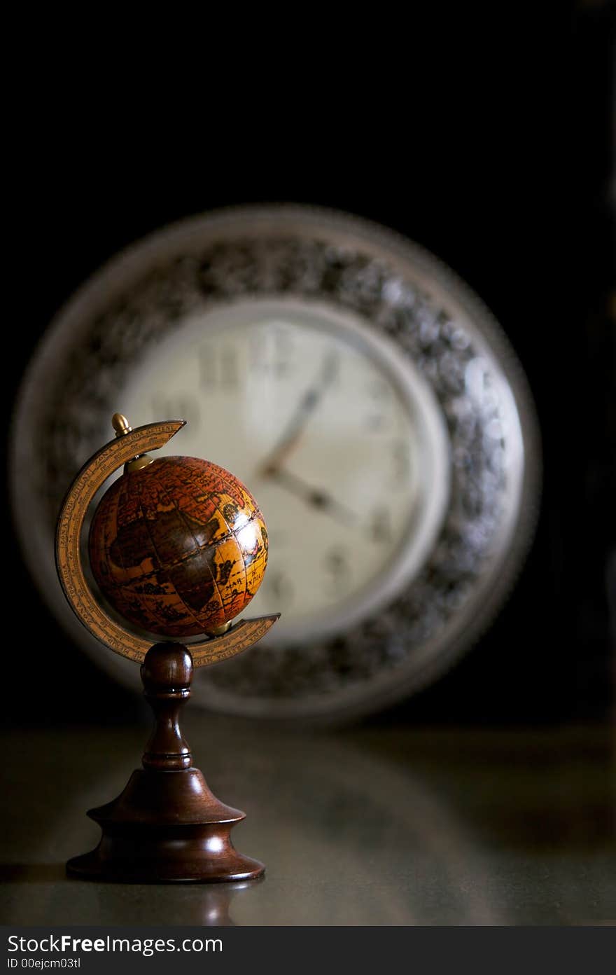 Miniature globe with clock in background