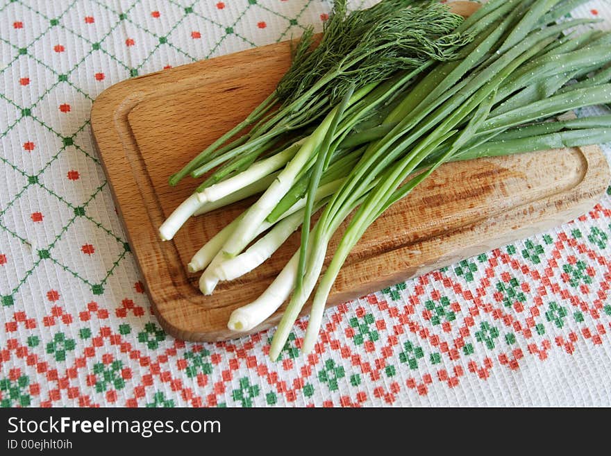 Leek with droplets of water on a wooden plate