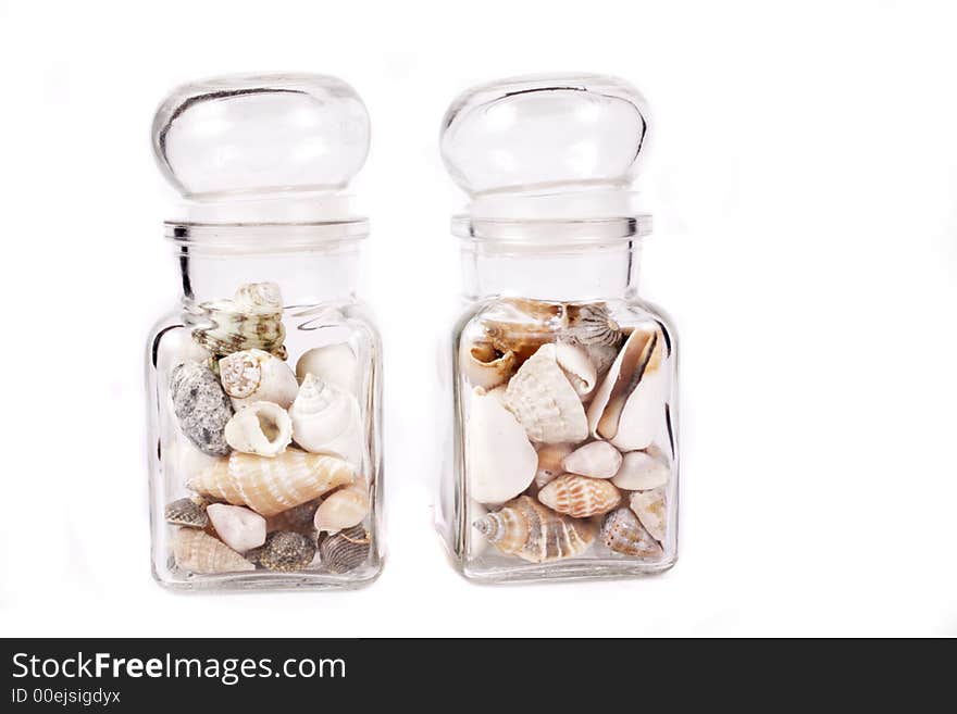 Small shells in jar on white background