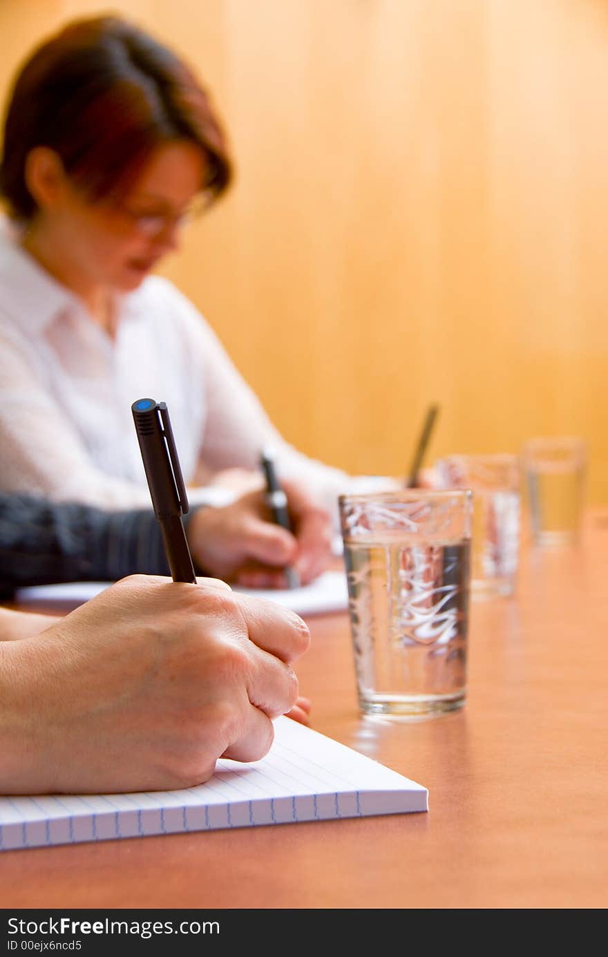 Business people writing in a meeting room. Business people writing in a meeting room