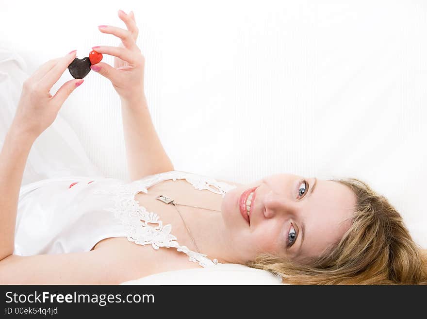 A blond women playing with red and black stone hearts. A blond women playing with red and black stone hearts