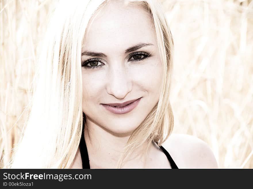 Portrait of a blonde woman with green eyes smiling, on a sunny day. Portrait of a blonde woman with green eyes smiling, on a sunny day.