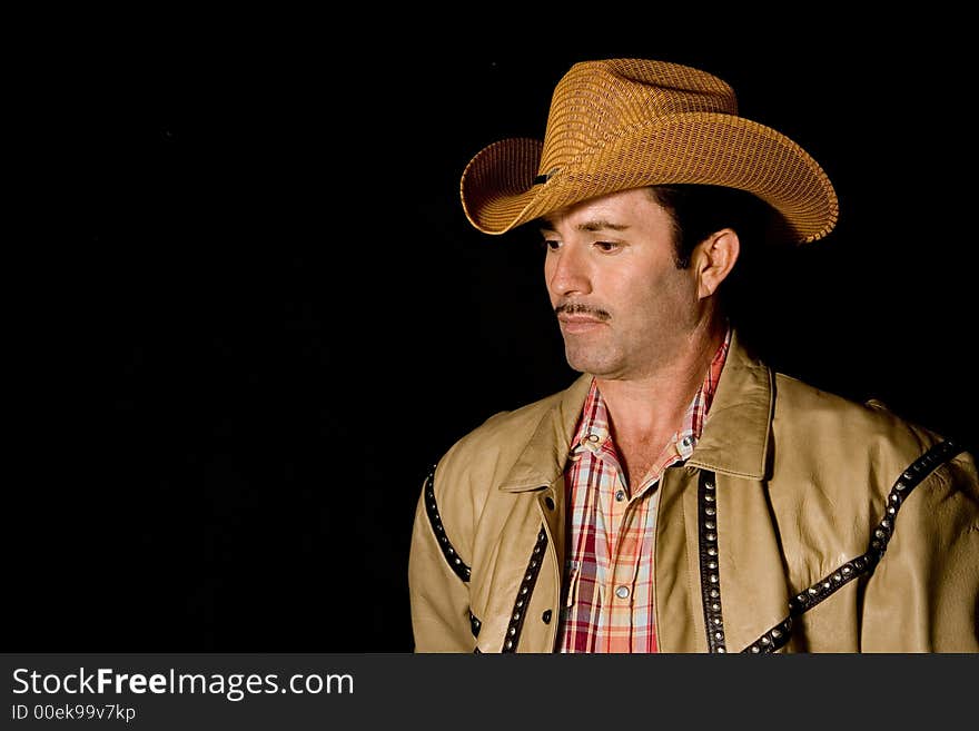 Adult cow boy looking down and posing for fashion shots. Adult cow boy looking down and posing for fashion shots