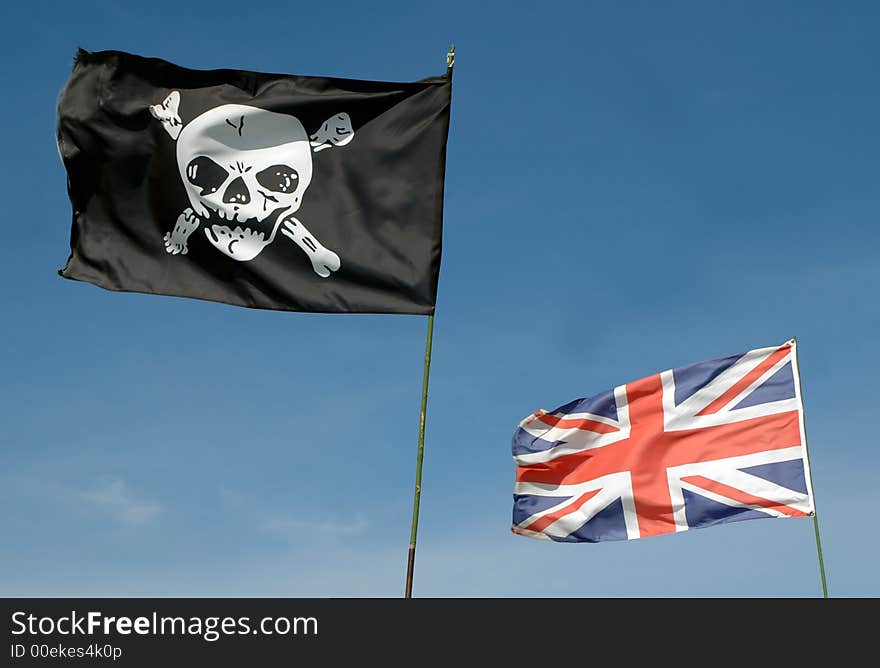 Skull and crossbones and GB union flag against blue sky. Skull and crossbones and GB union flag against blue sky