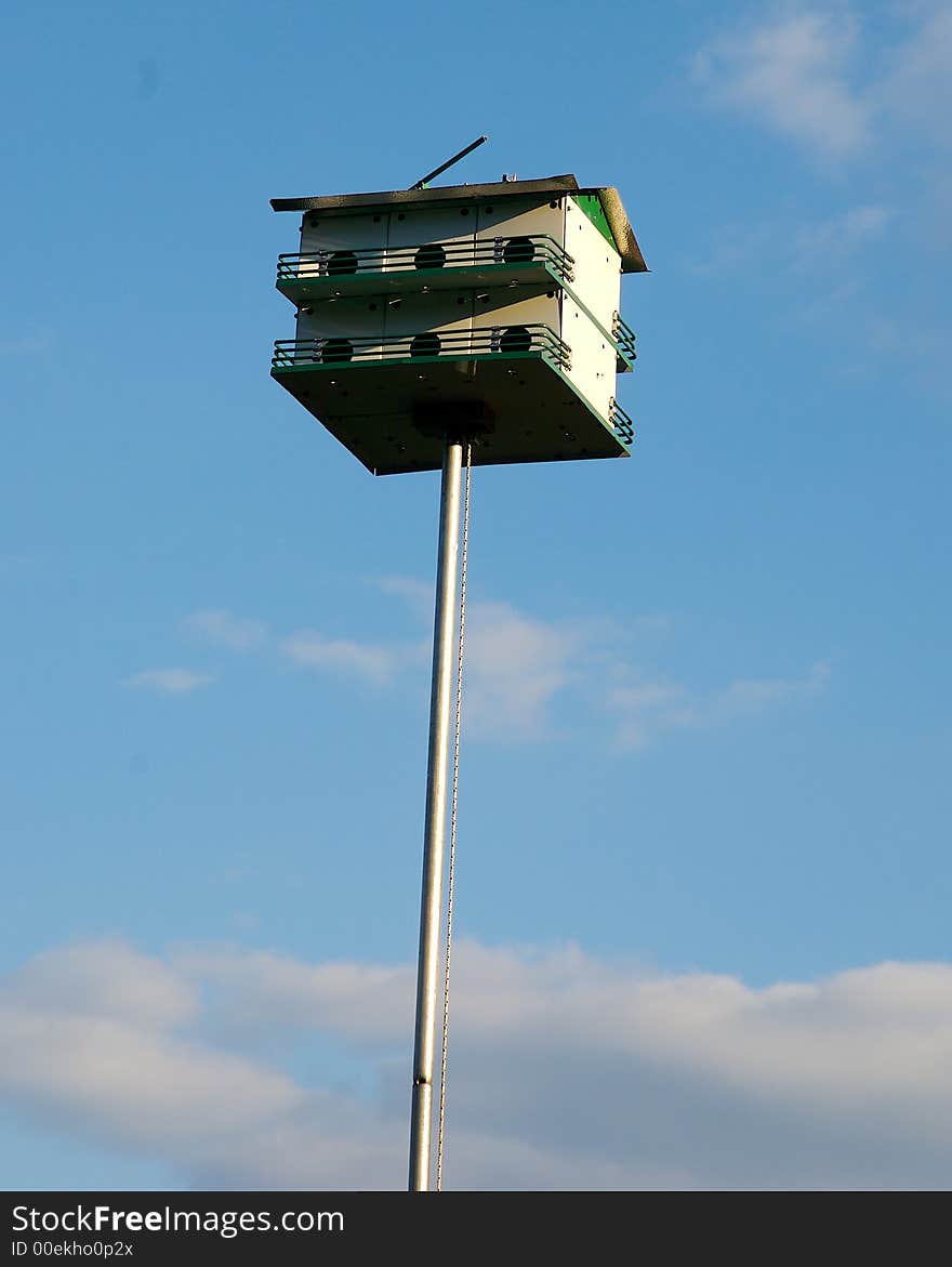 A bird feeder on a blue sky background