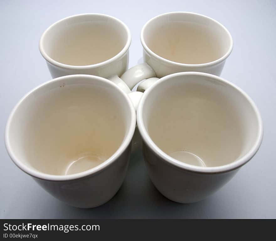 Four white drinking cups on a white bakcground