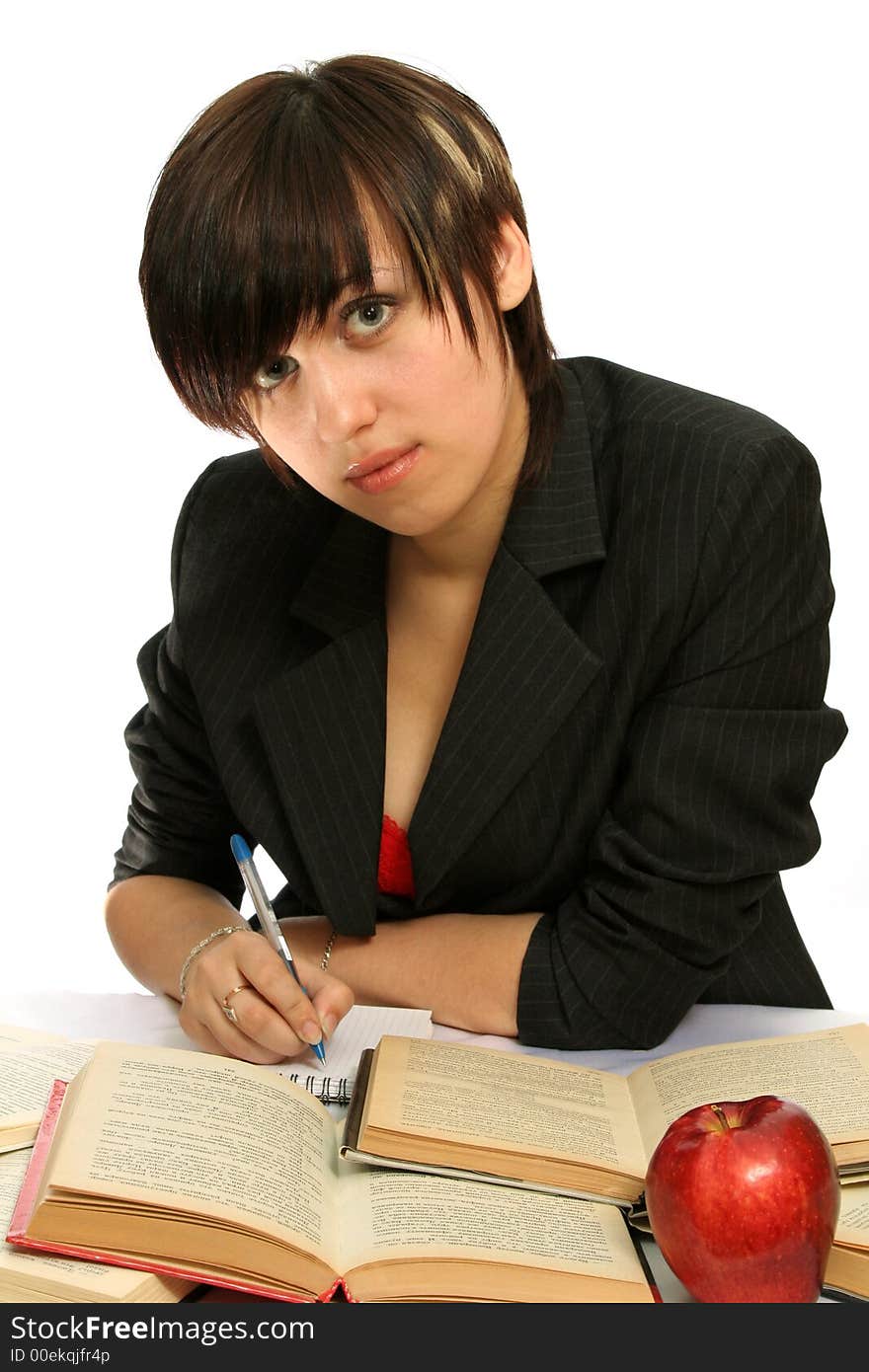 The young girl with books and a red apple, isolated on white