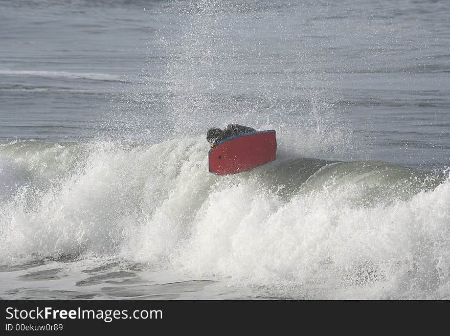 Photo of a bodyboarder on top of the wave