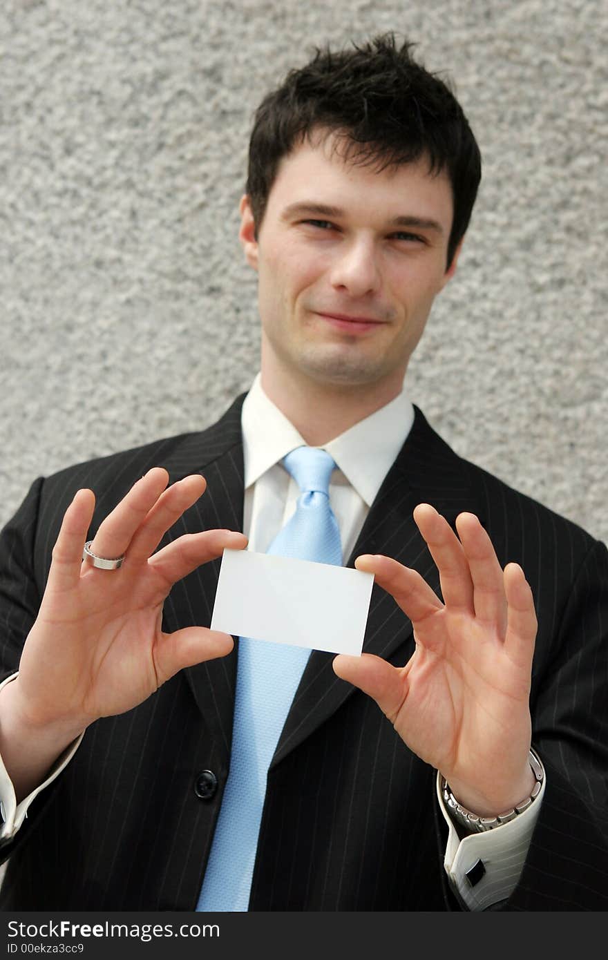 Businessman holds a blank card - add your own text. Focus on the card.