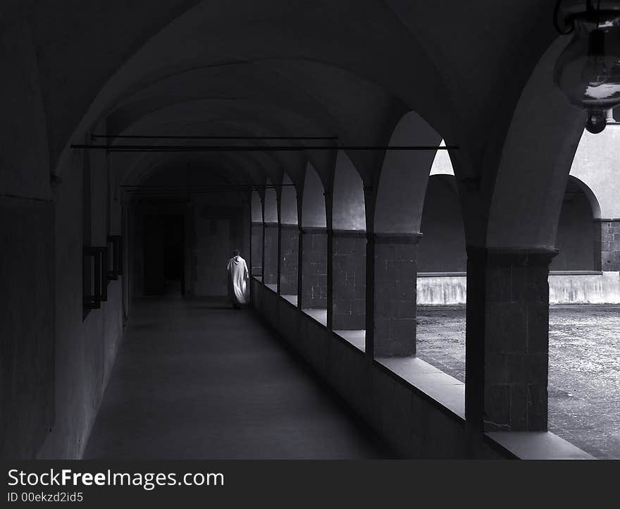 A monk walking alone in the monastery cloisters. A monk walking alone in the monastery cloisters