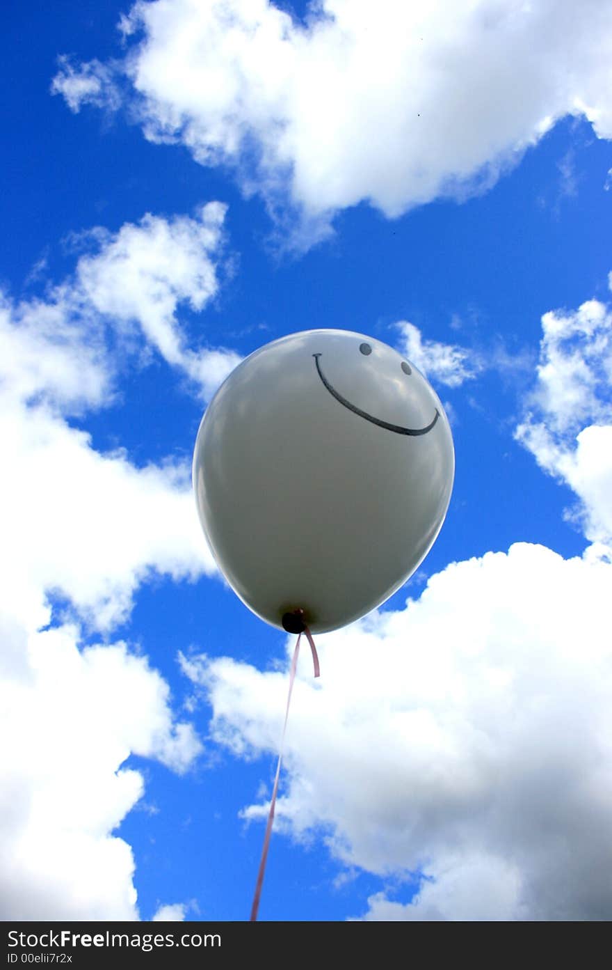 Balloon with smiley face against blue sky with clouds. Balloon with smiley face against blue sky with clouds.