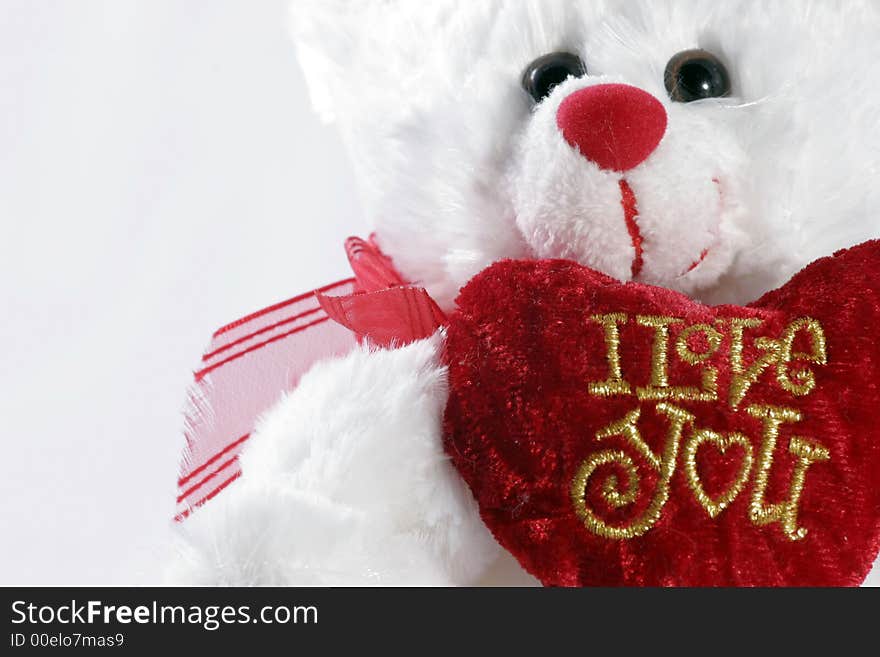 White teddy bear on white background holding heart with 'I love you'. White teddy bear on white background holding heart with 'I love you'