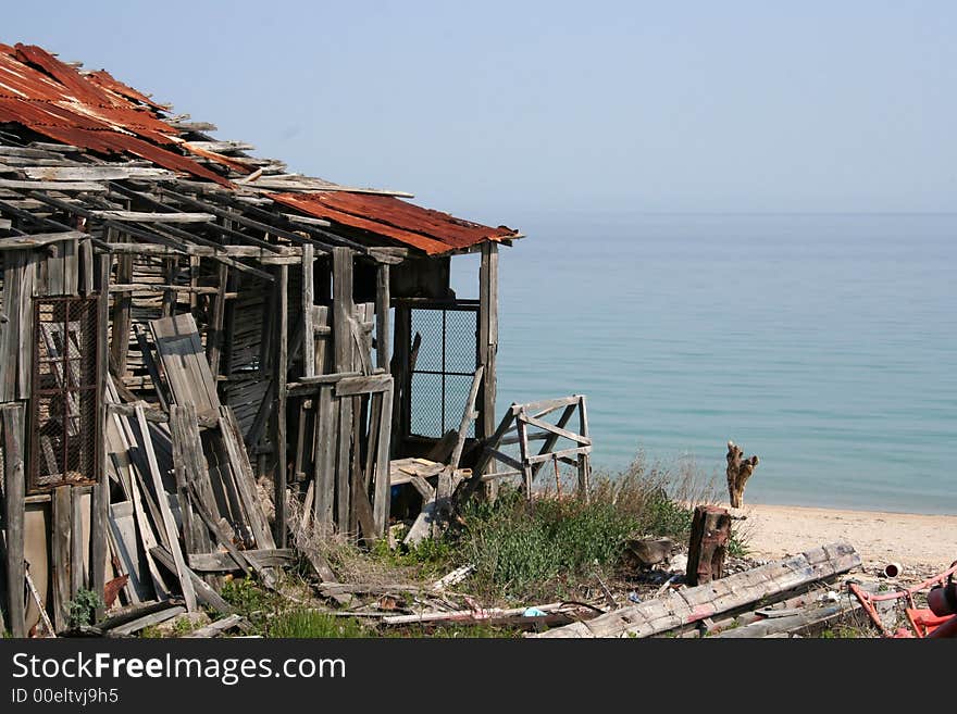 Delapidated boathouse on sea front with copy space