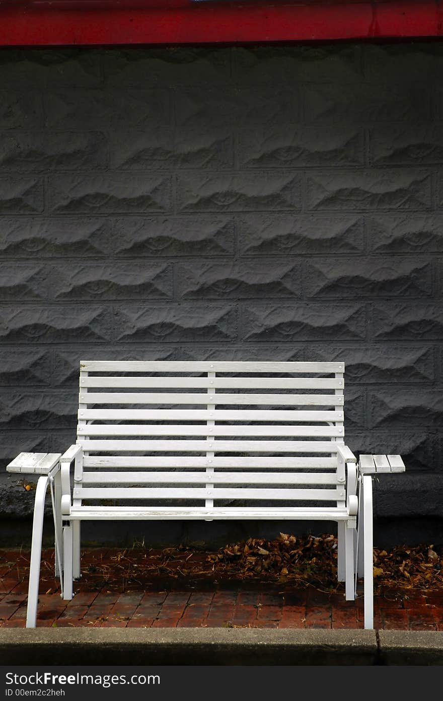 White park bench with gray brick background