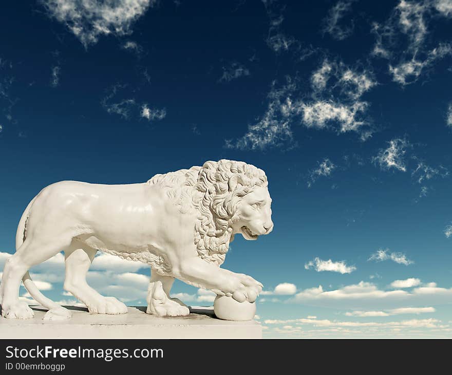 Sculpture of a white lion on a background of the blue sky