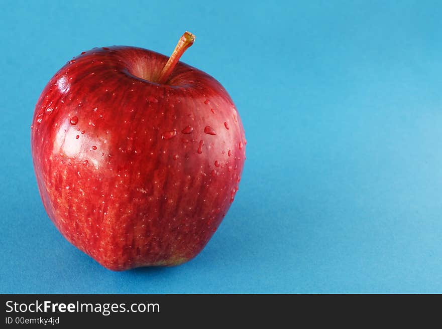 A red apple on blue background.