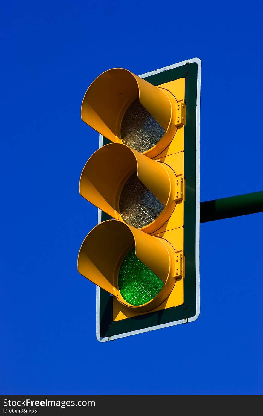 Green traffic light on blue sky